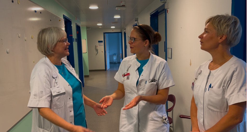 tre sygeplejersker i uniform taler sammen 
