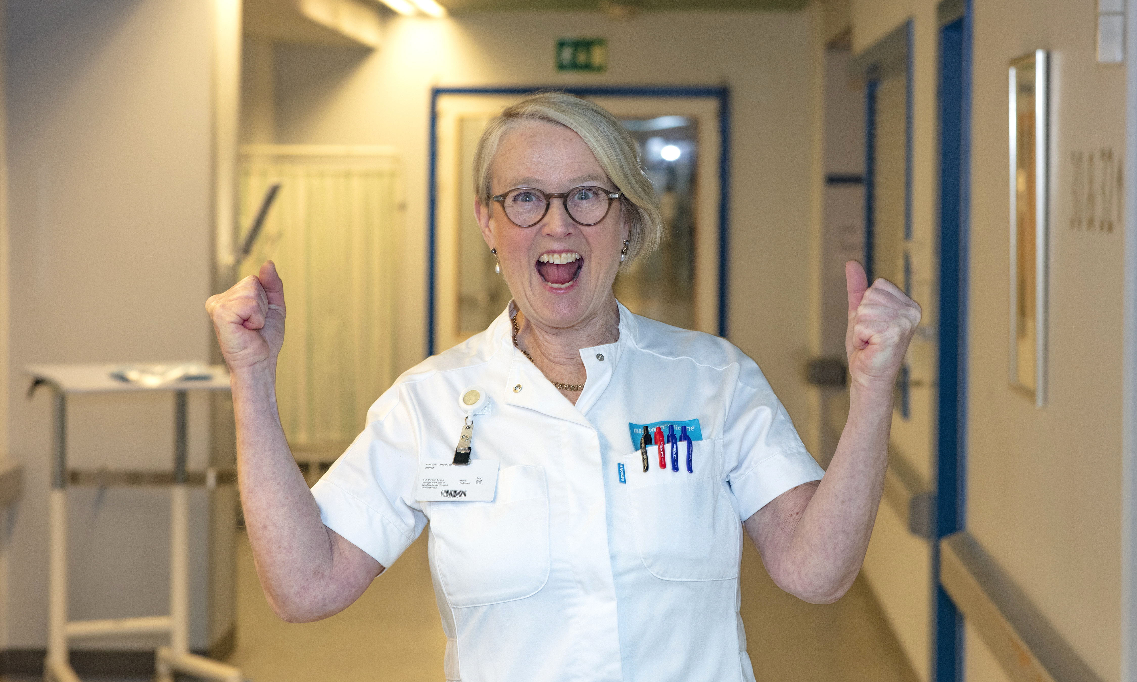 Implementerings- og forbedringsspecialist jubler og ser glad ud på hospitalsgang